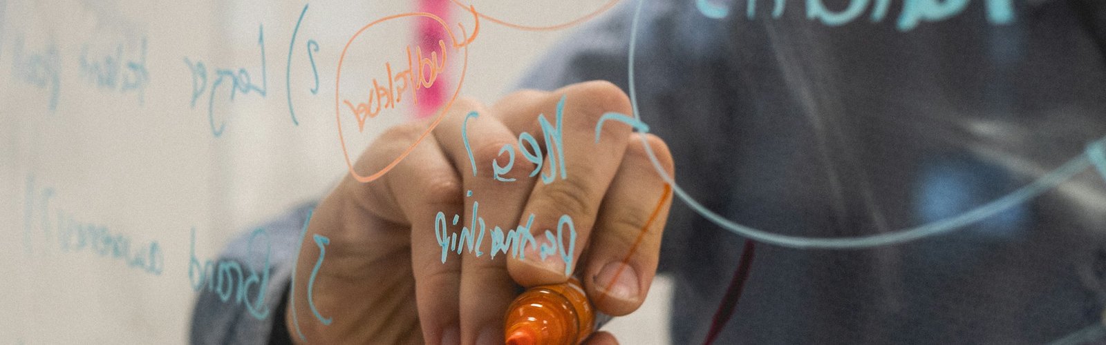 Consultant sketching ideas on a glass whiteboard