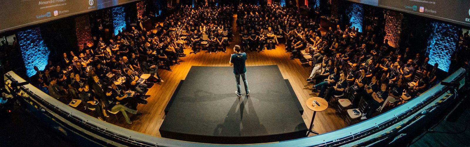 Speaker on a stage in front of a large conference audience