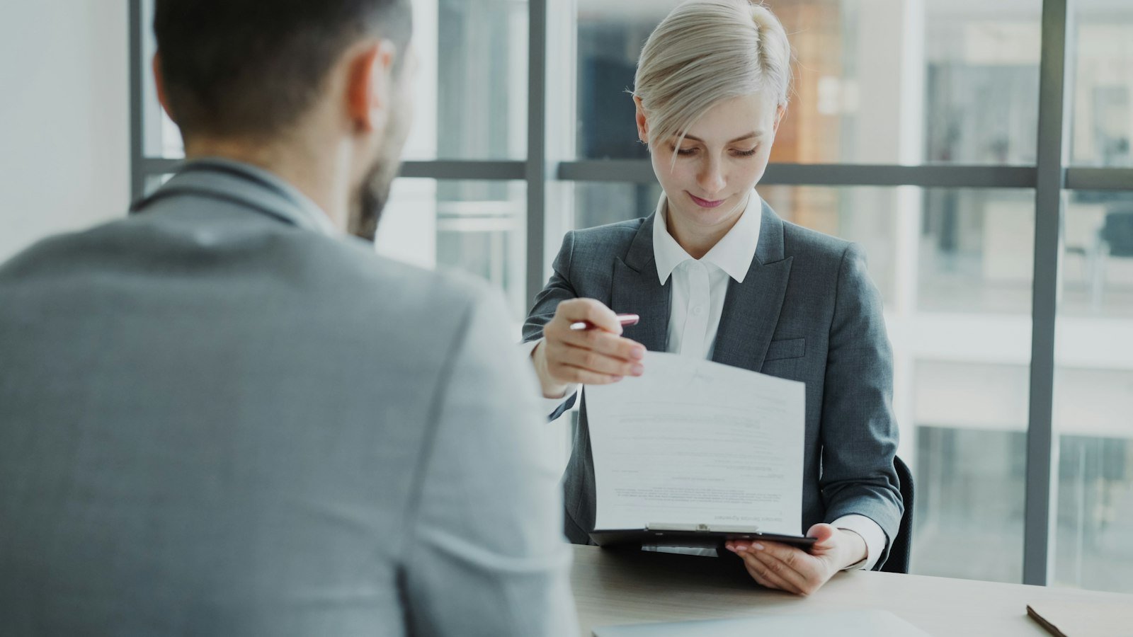 Business funding options: Woman in suit shows document to man