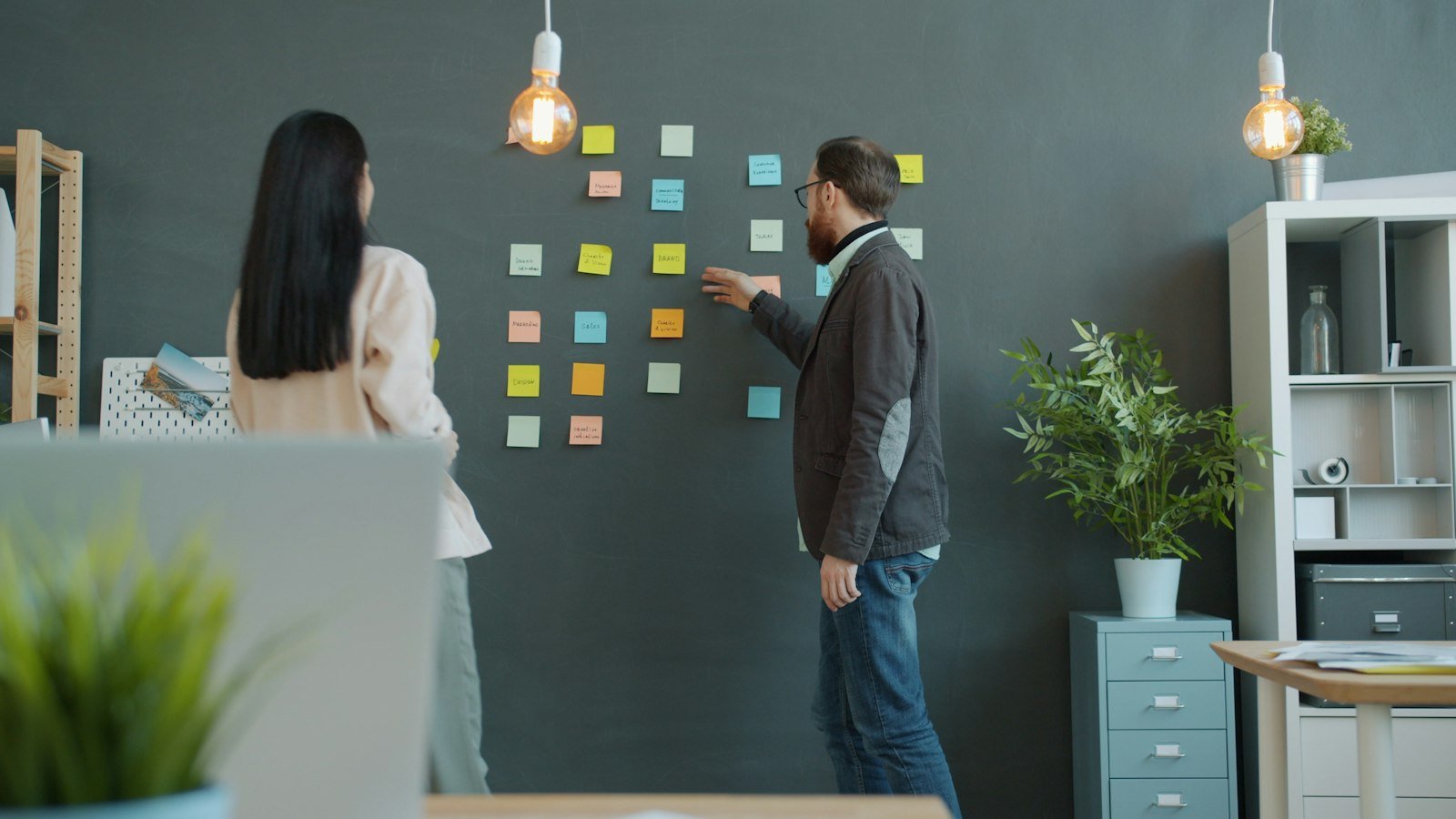 Business opportunities for creative people: Two people planning with sticky notes on wall