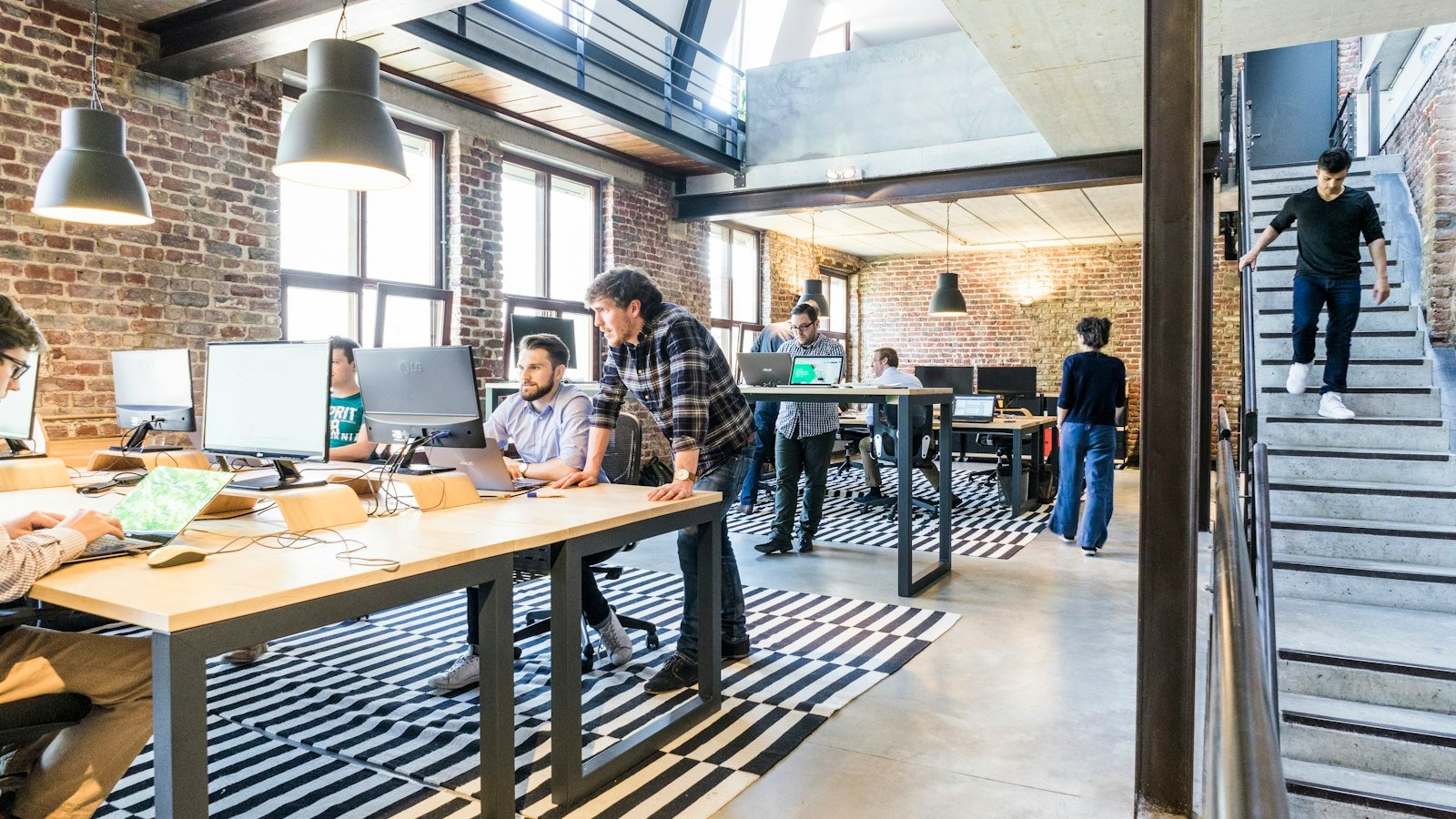 Business opportunities for introverts: man standing beside another sitting man using computer