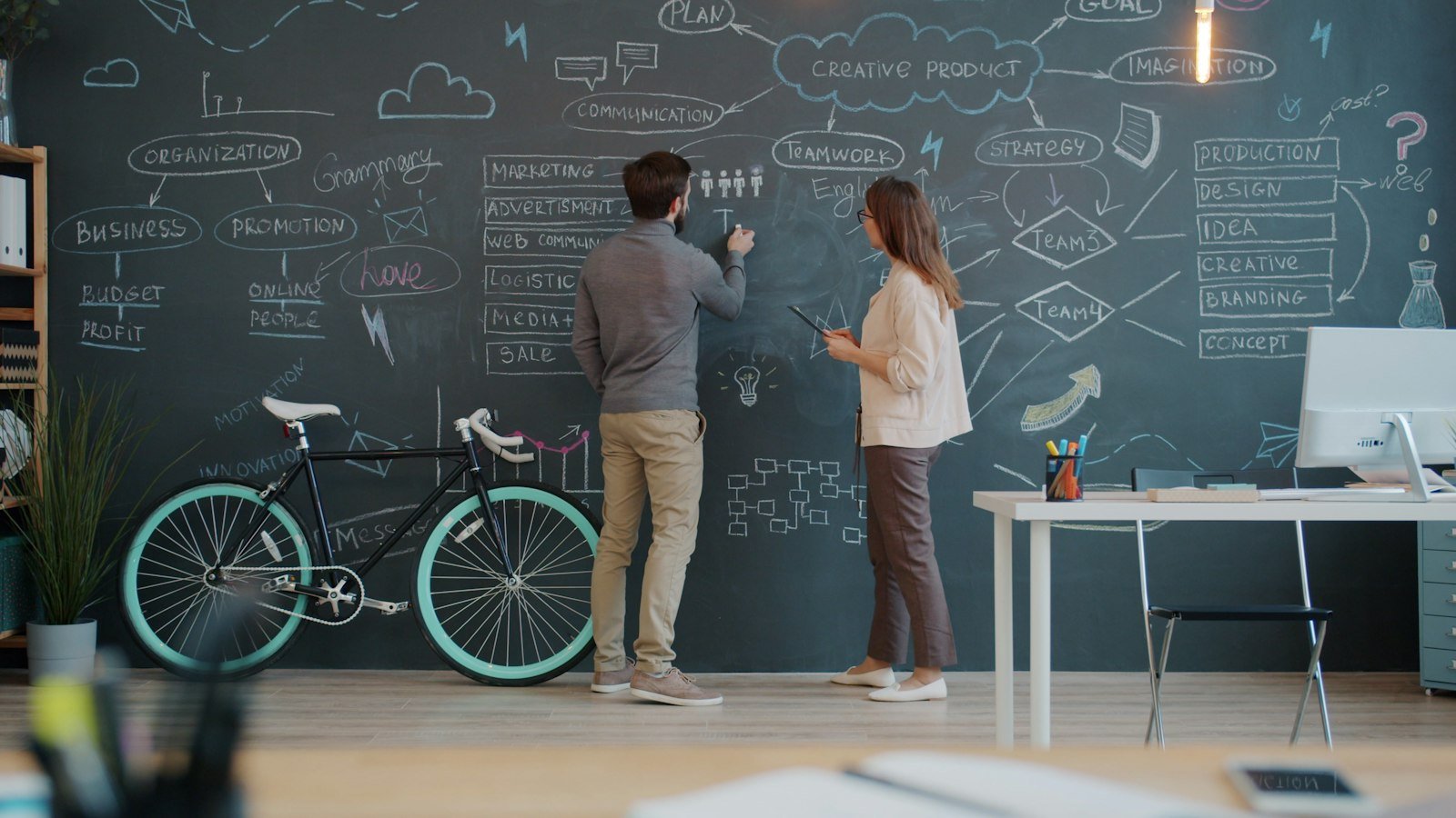 Business opportunities with limited capital: Two people drawing on a chalkboard wall