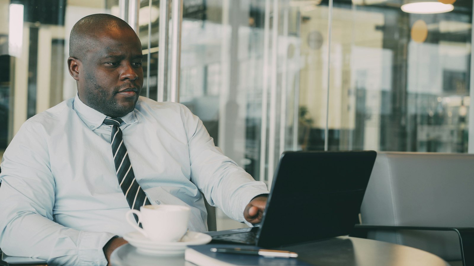 Business opportunity listing: Man in a suit working on a laptop with coffee