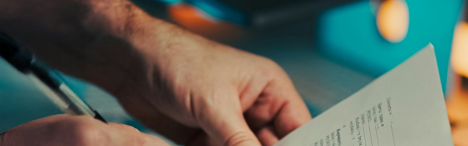 Man signing a document with a pen