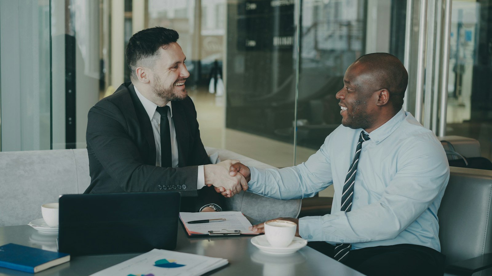 Buy a business with no experience: Two businessmen shaking hands across a table