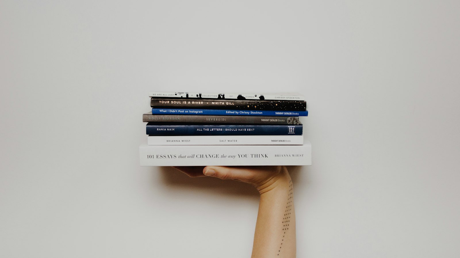 Dare to lead book: person holding pile of books