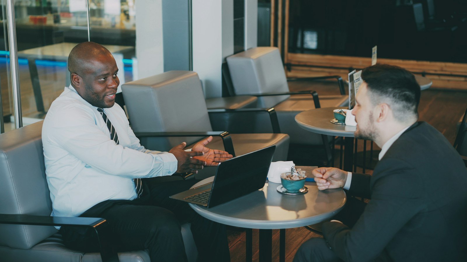 Email marketing for business opportunity companies: Two businessmen talking at a cafe table