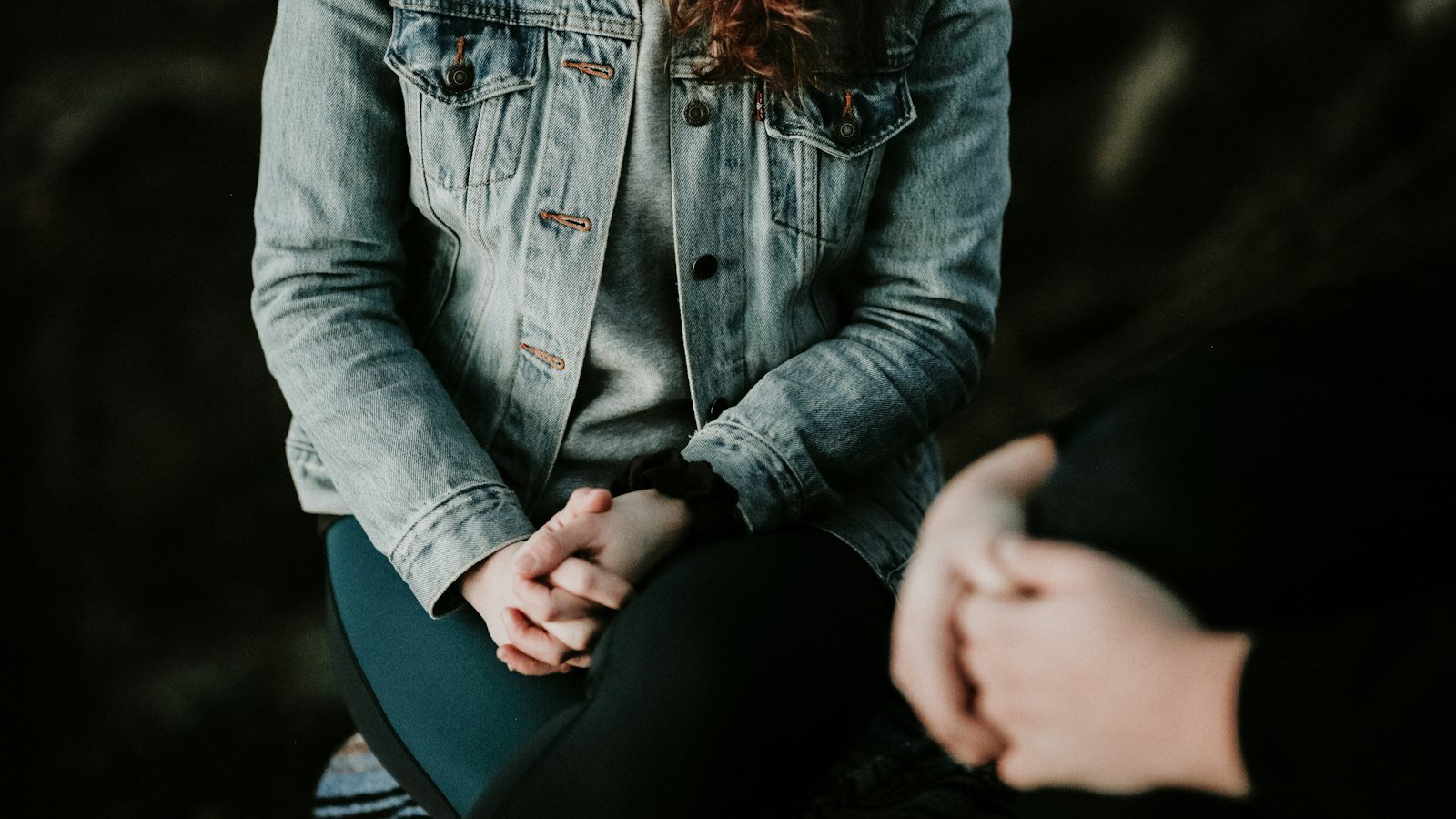 Emotions of selling a business: woman in denim jacket sitting