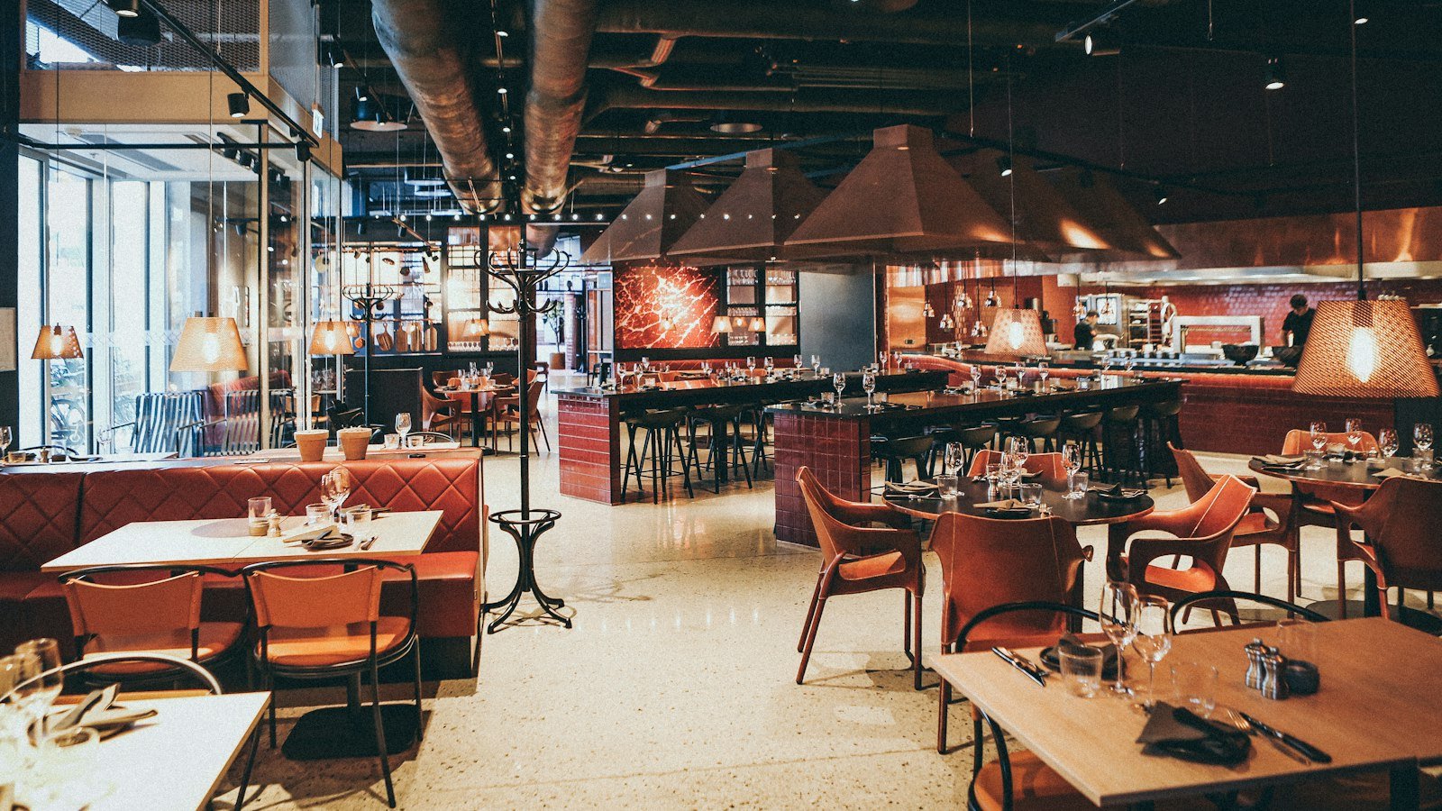 Franchise validation calls: A modern restaurant interior with red leather booths, wooden tables, and hanging