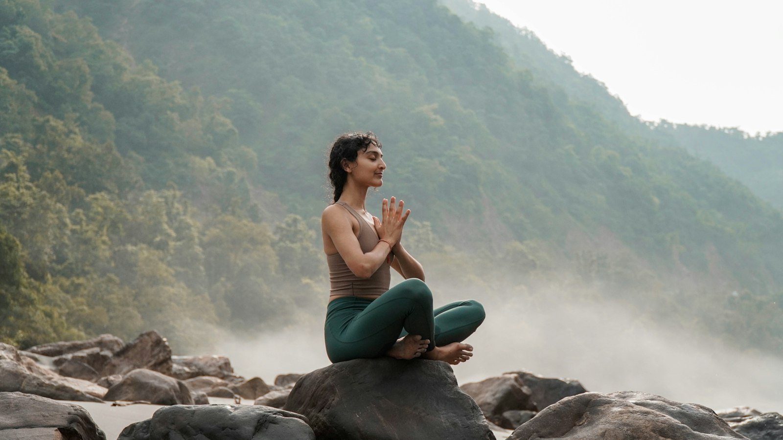 Healthy eating for busy owners: a woman sitting on top of a rock next to a river