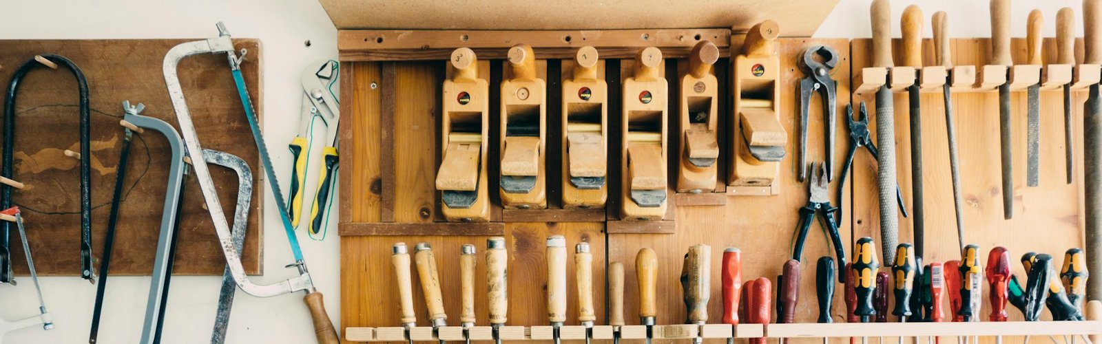 Hand tools arranged on a wooden workshop wall