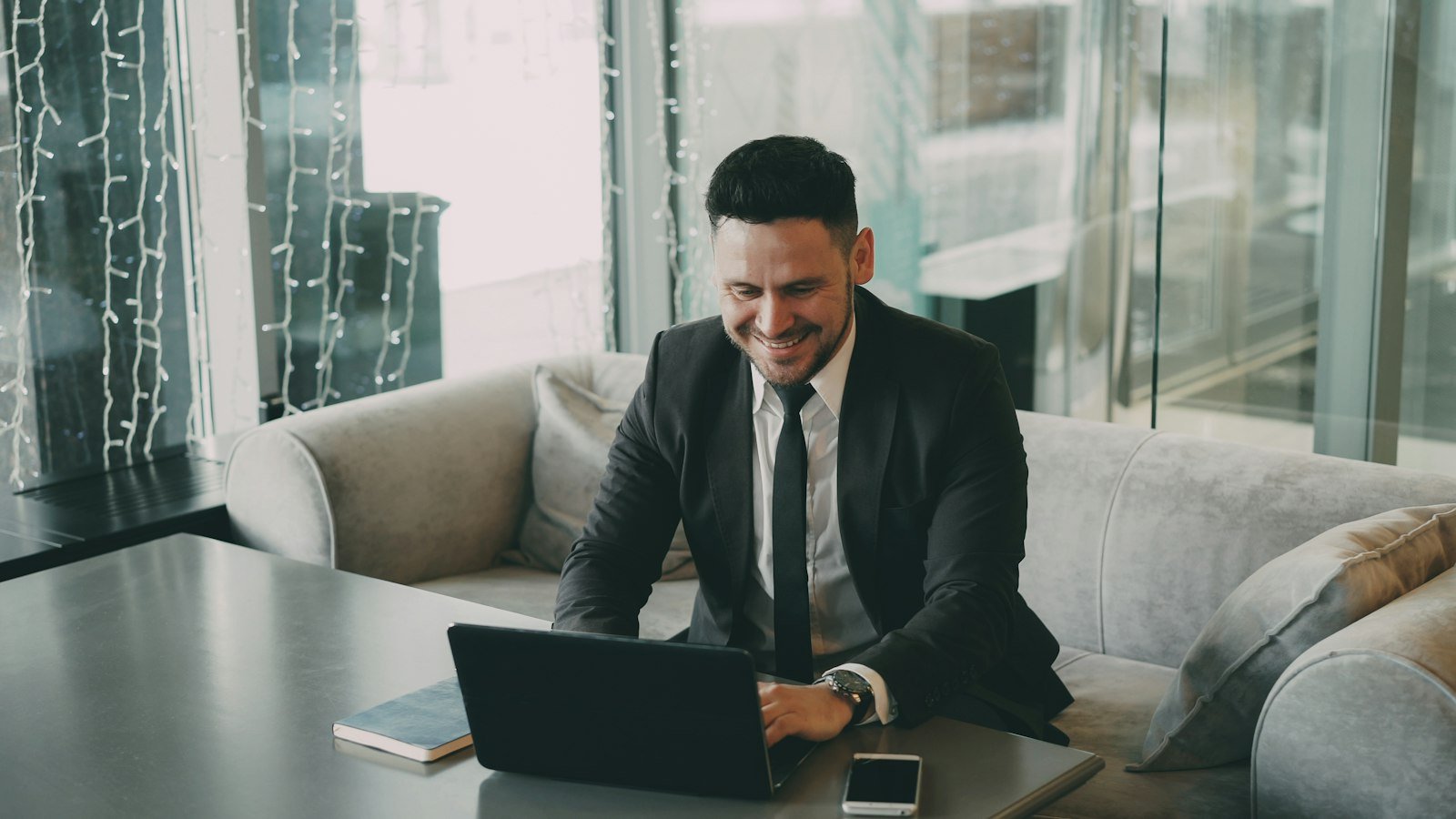 How to get an ein: Man in suit smiling while using a laptop
