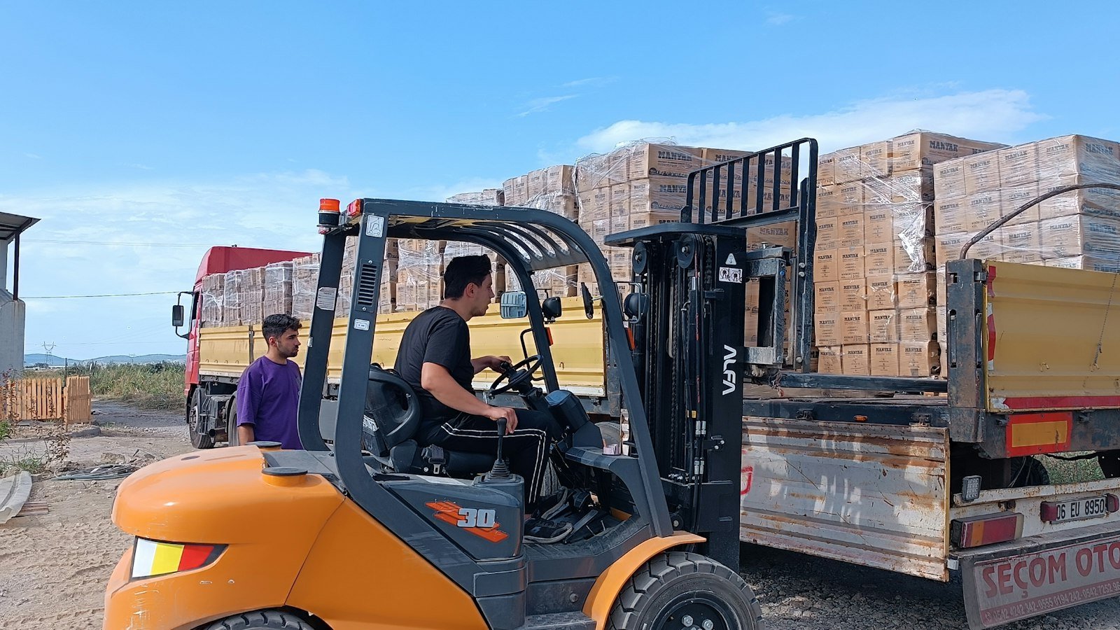 How to value a distributorship: Forklift loading bricks onto a truck outdoors
