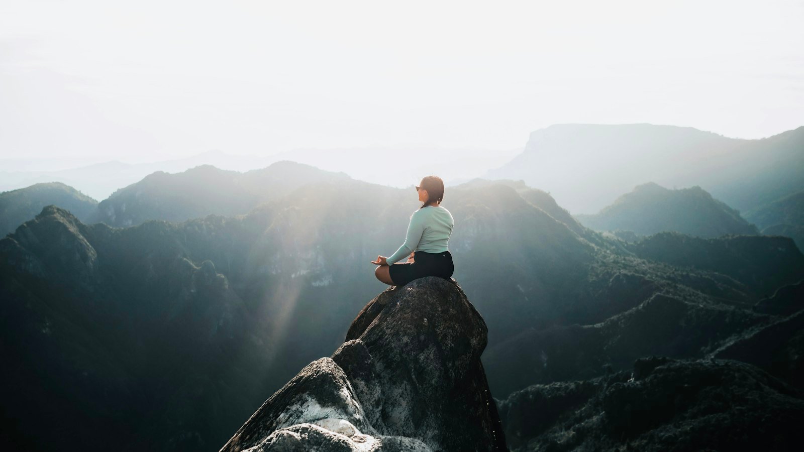 Mental health days for business owners: a man sitting on top of a large rock