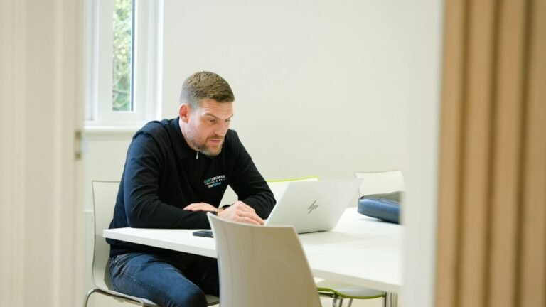Military spouse business opportunities: Man working on laptop at a white table