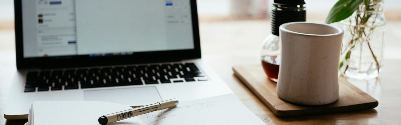 Online education business opportunities: Laptop next to an open white book for online learning