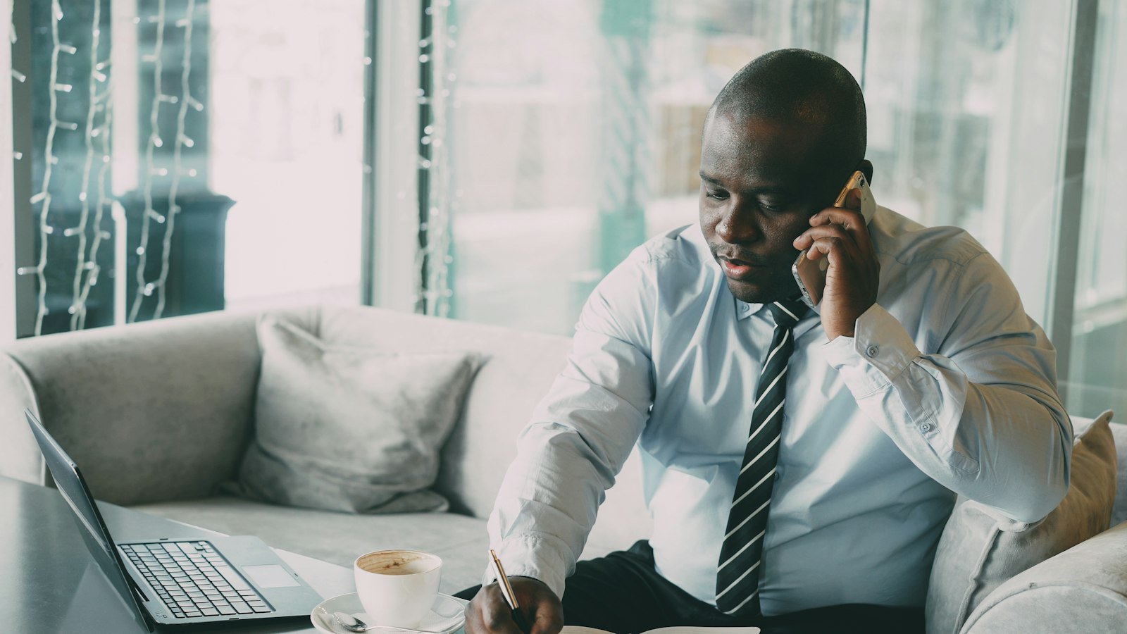 Passive income myths: Man in shirt and tie talking on phone at desk