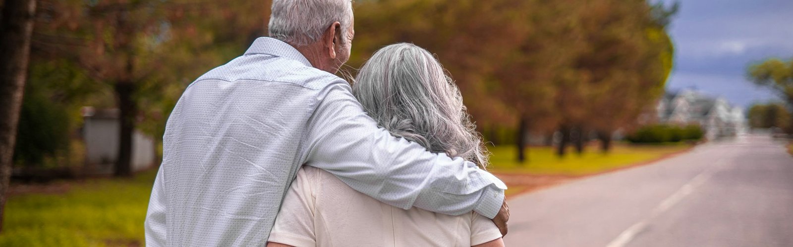 Older couple walking arm in arm outdoors