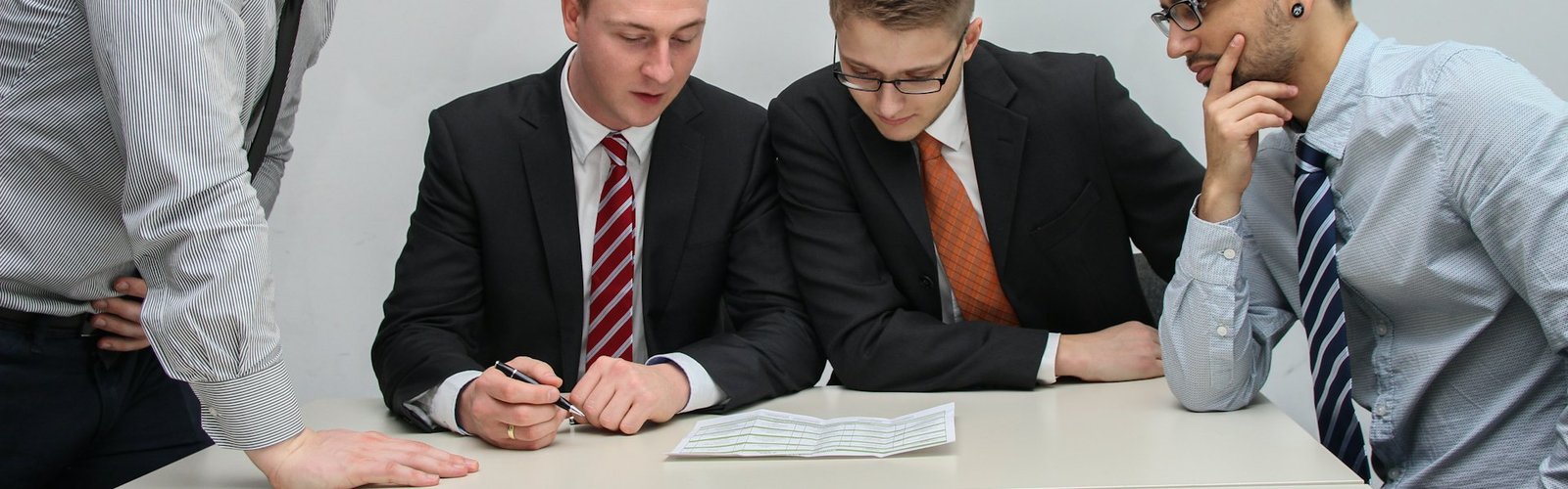 Two men in suits reviewing a document at a desk