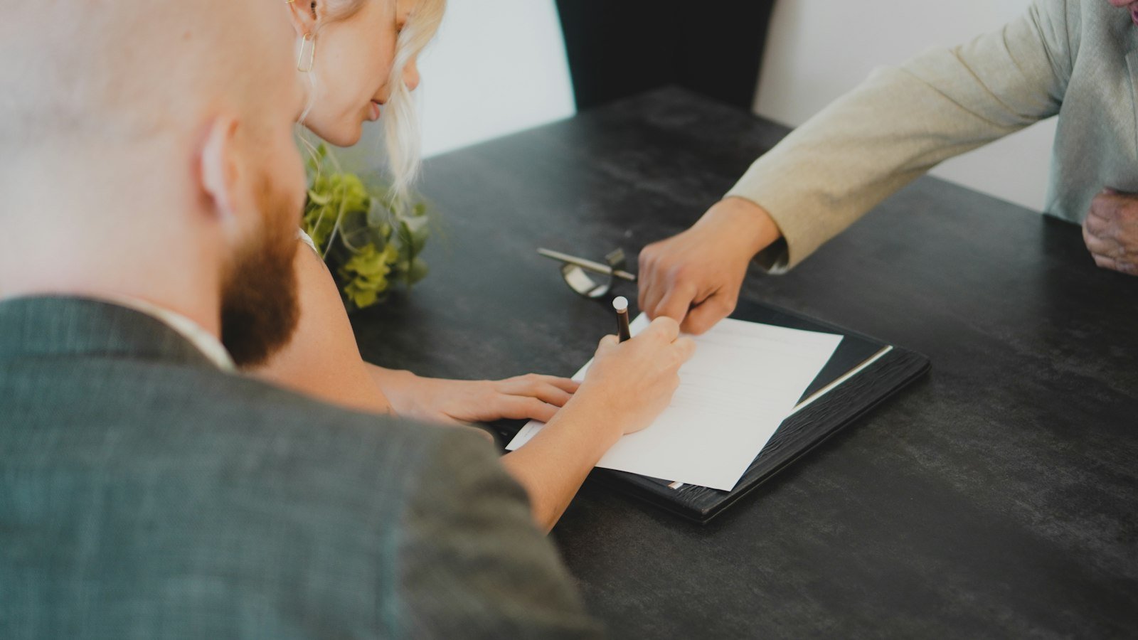 Steps to buy a business: couple signing document at desk