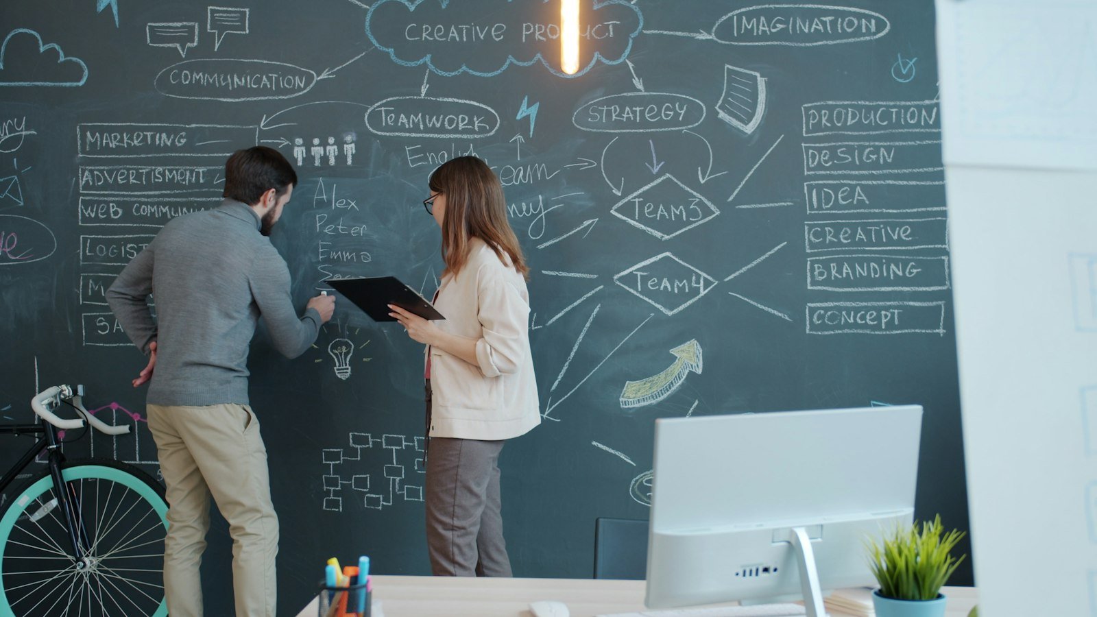 Tech business opportunities: Two people brainstorming on a chalkboard wall