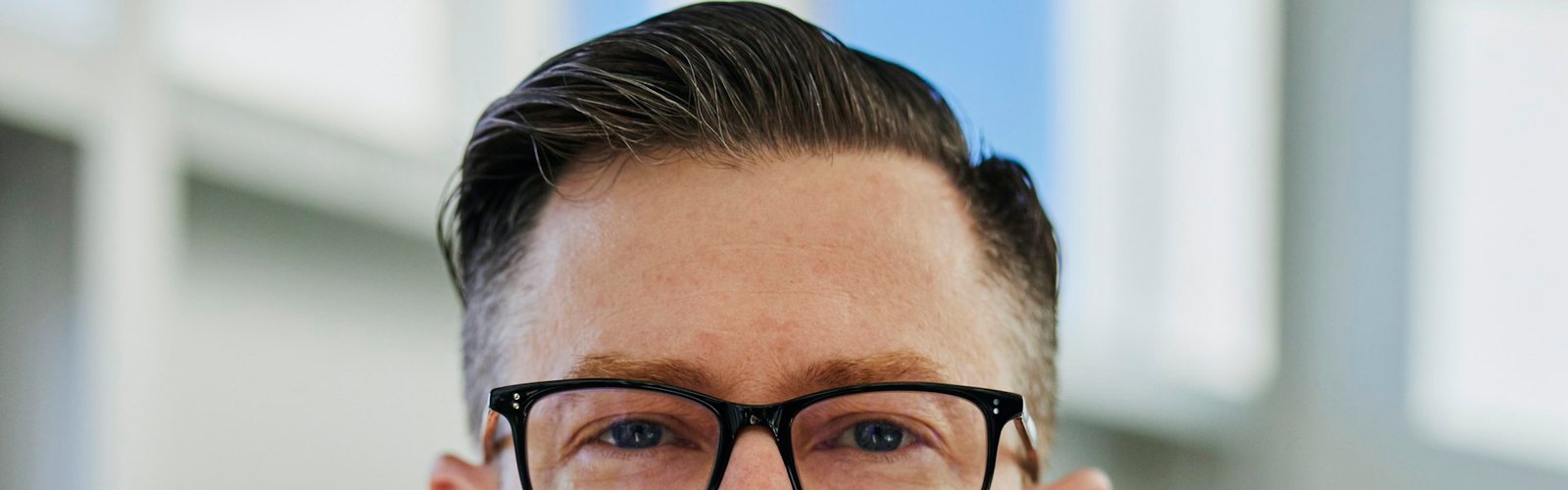 Close-up portrait of a man in glasses in an office