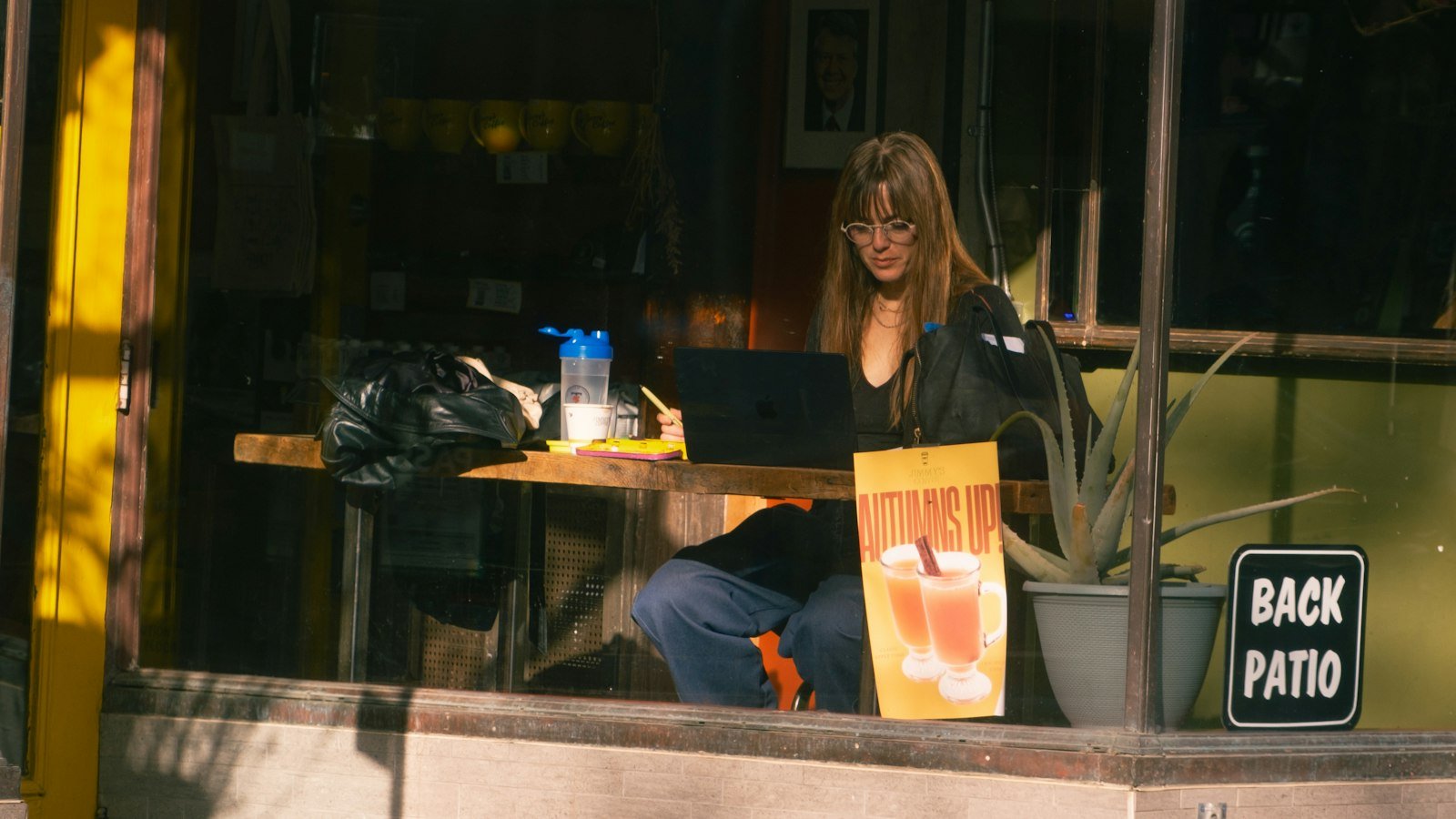 Time blocking for business owners: Woman working on laptop at outdoor cafe table