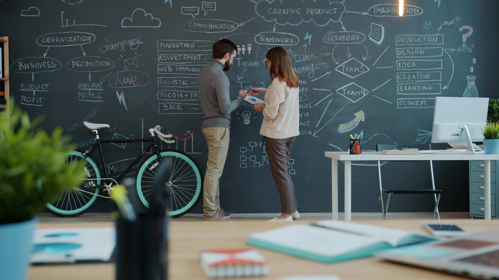 Which business opportunity is right for me: Two people discussing a diagram on a chalkboard wall