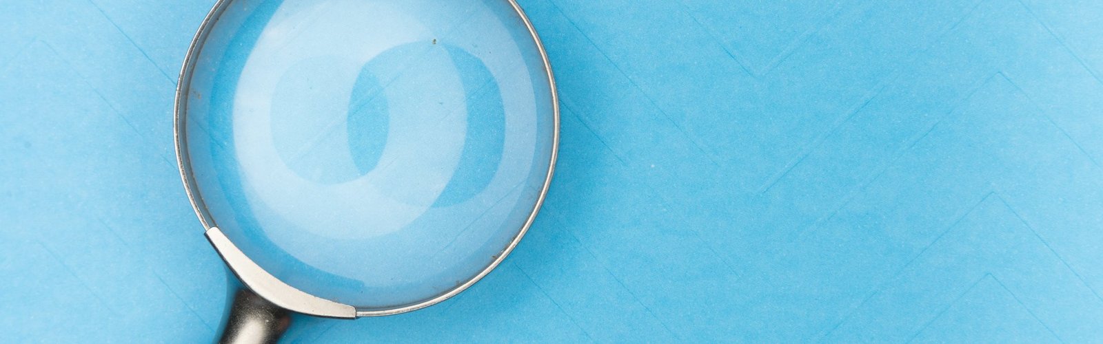 Magnifying glass over a bright blue surface